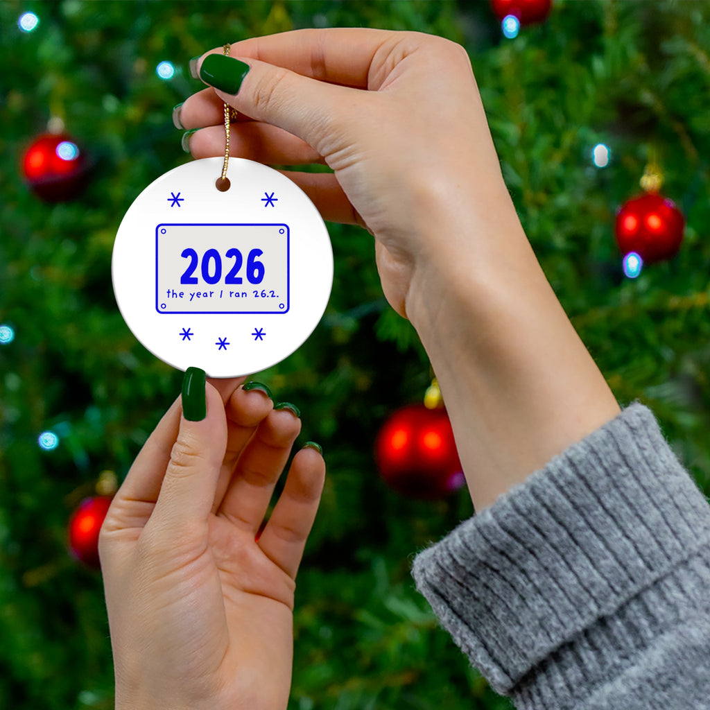 2026 marathon ornament held in front of a Christmas tree