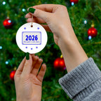 2026 marathon ornament held in front of a Christmas tree